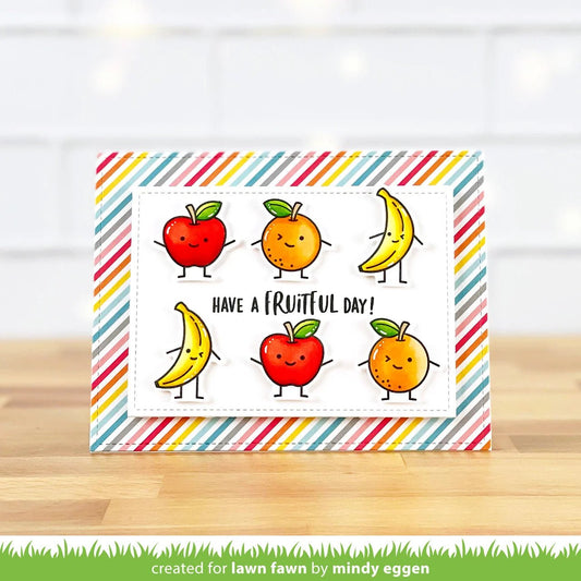 Grusskarte mit diagonalem Regenbogenstreifenhintergrund und sechs Früchten mit Smileyfaces.