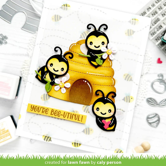 Grusskarte mit drei Bienen zwei halten eine Blume, und eine ein Herz. Im Hintergrund der gestanzte Bienenstock