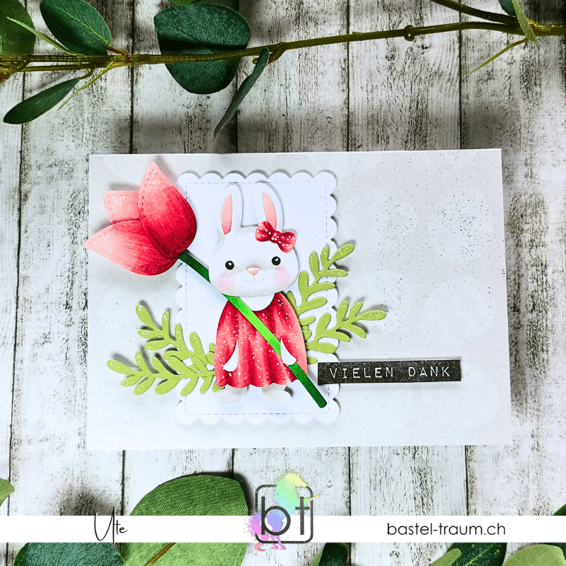 Dieser Hase von Lawn Fawn hält eine Tulpe in der Hand, Bekleidet in einem roten Kleid mit roter Schleife vor einem der Ohren und hat zwei rosige Wnagen, Altenew Sentiment Vielen Dank