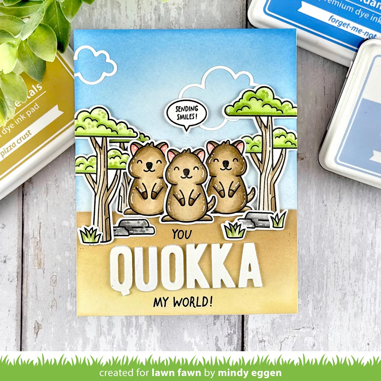 Grusskarte mit drei lustigen Quokkas in der Savanne.