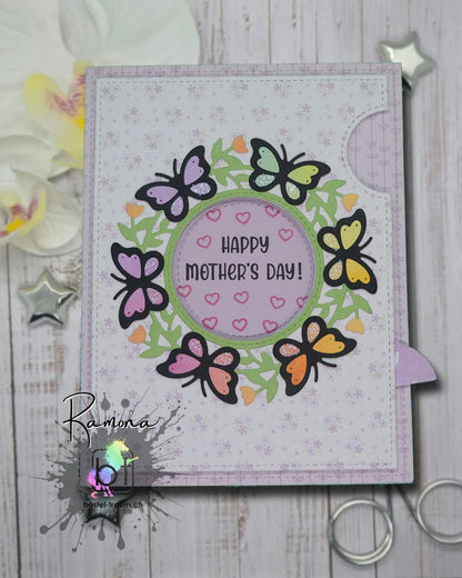 Eine Karte mit einer Iris welche geöffnet werden kann. Jetzt offen mit dem Text Happy Mothers day! Rundum mit Schmetterlingen und Blüten. 